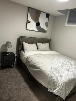 a bedroom with a bed and a picture on the wall at Bright & Spacious 2BR Getaway in Calgary