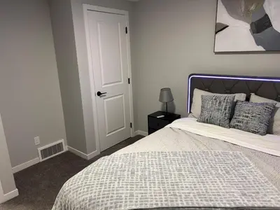 a bedroom with a bed with a blue and white comforter at Bright & Spacious 2BR Getaway in Calgary