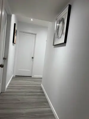 a hallway with white walls and a white door at Heavenly Cozy Place Inc in Airdrie