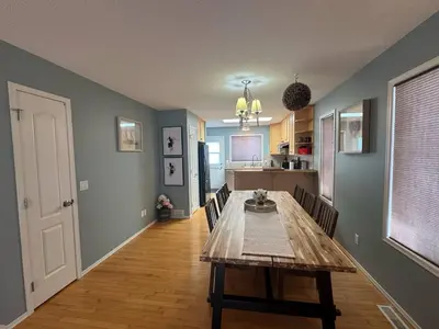 a dining room with a table and a kitchen at Heavenly Cozy Place Inc in Airdrie