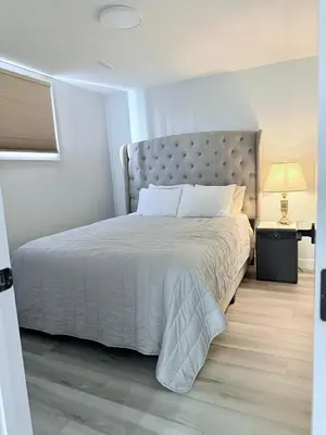 a bedroom with a white bed with a silver headboard at Spacious 2 bedroom 3 beds lower unit with separate entrance and parking space Near Downtown, Calgary Zoo, Costco and many more in Calgary