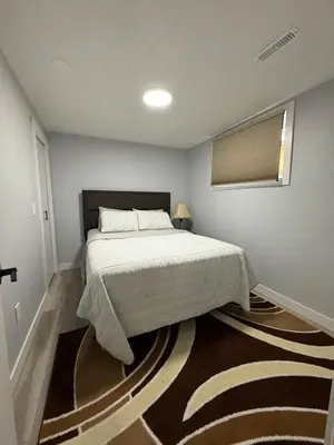 a bedroom with a bed and a rug at Spacious 2 bedroom 3 beds lower unit with separate entrance and parking space Near Downtown, Calgary Zoo, Costco and many more in Calgary