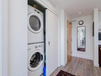a laundry room with a washer and dryer at Sunset Place-Deluxe One Bedroom Condo in the Escher Building, Sunset Views and Beyond in Victoria
