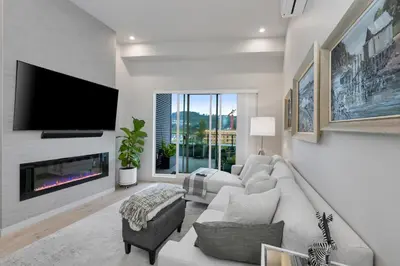 a living room with a couch and a tv at Whirlaway – Luxurious one bedroom Penthouse with study and 2 parking spots by Victoria Prime! in Victoria