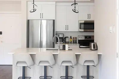 a kitchen with white cabinets and a counter with stools at Riverstone Retreat in Golden BC in Golden