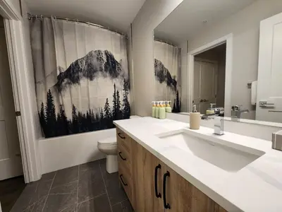 a bathroom with a sink and a toilet and a mirror at Riverstone Retreat in Golden BC in Golden