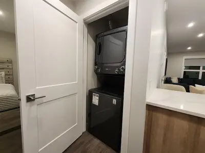 a bathroom with a tv and a black refrigerator at Riverstone Retreat in Golden BC in Golden