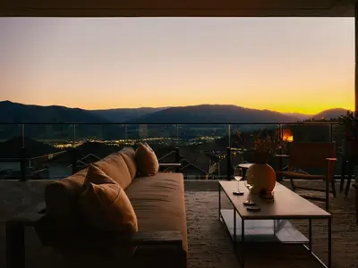 a living room with a couch and a table and a sunset at Bialto Bed and Breakfast in Penticton