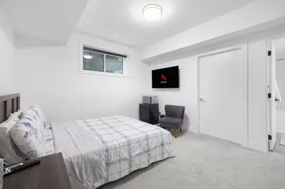 a bedroom with a bed and a desk and a chair at Studio Suite in Northeast, Edmonton in Edmonton