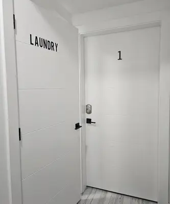 a white door with the word laundry written on it at Studio Suite in Northeast, Edmonton in Edmonton