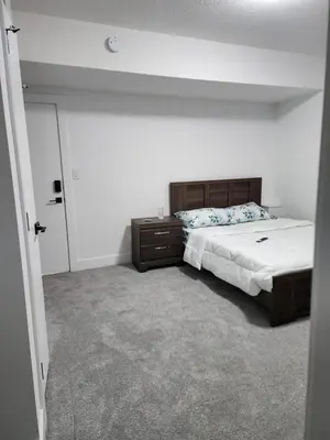 a bedroom with a bed and a dresser in it at Studio Suite in Northeast, Edmonton in Edmonton