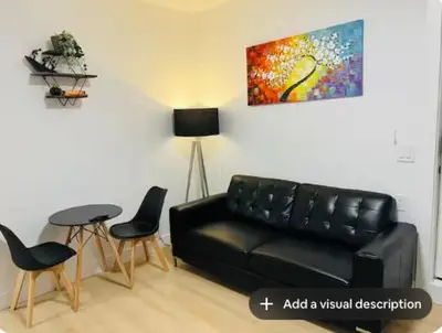 a living room with a black leather couch and chairs at New and Modern 1 bedroom suite near beach in Surrey