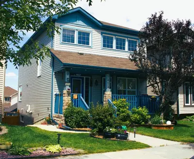 a house with a blue door and a yard at Entire suite Queen BRM Big Window Prvt Entry Patio in Edmonton