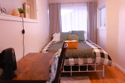 a small bedroom with a bed with a teddy bear on it at Entire suite Queen BRM Big Window Prvt Entry Patio in Edmonton