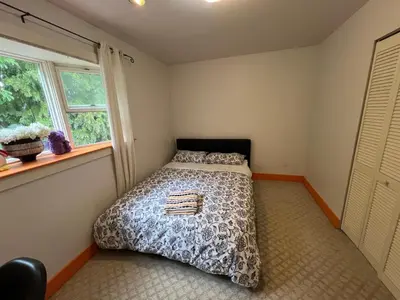 a bedroom with a bed and a window at Sweet Home in Vancouver