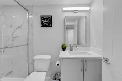 a white bathroom with a sink and a shower at TheCozyNest in Calgary