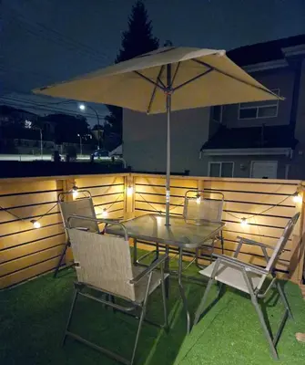 a table and chairs with an umbrella on a patio at Charming Beautiful Private Room With Private Bath and Parking! Near Metrotown in Burnaby