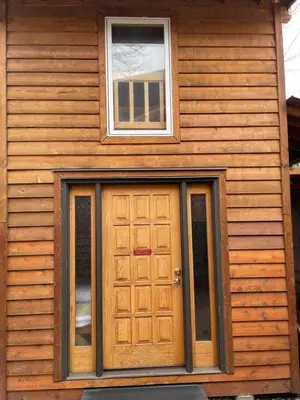 a wooden house with a door and a window at Luna Bed & Breakfast in Grand Forks