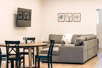 a living room with a couch and a table and chairs at Revy To Go - Unique 2-Bedroom Condo in Revelstoke