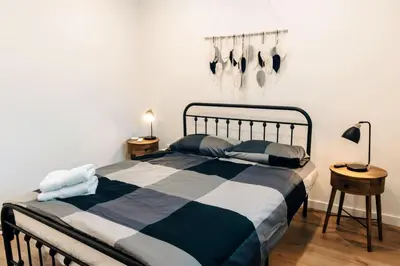 a bedroom with a black and white bed and two tables at Revy To Go - Unique 2-Bedroom Condo in Revelstoke