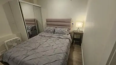 a small bedroom with a bed and a mirror at Your Home - Spacious Private Suite in Delta