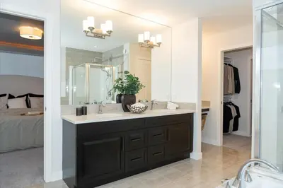 a bathroom with a sink and a large mirror at Strawberry Fields 4BD Family Movie Room Office in Calgary