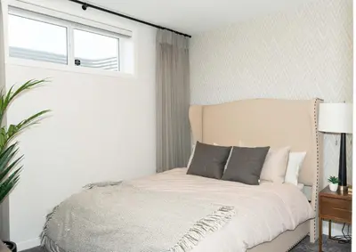 a bedroom with a bed and a window and a window at Strawberry Fields 4BD Family Movie Room Office in Calgary