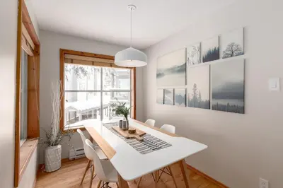 a dining room with a white table and chairs at 1BR in Powderview, Creekside, Bright and Cozy, Private Ski Storage, Fireplace, Free Parking in Whistler