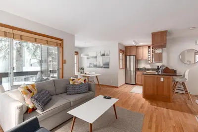 a living room with a couch and a kitchen at 1BR in Powderview, Creekside, Bright and Cozy, Private Ski Storage, Fireplace, Free Parking in Whistler