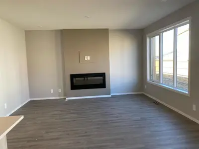 an empty living room with a fireplace and a tv at Cozy House In Airdrie in Airdrie