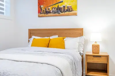 a bedroom with a bed with yellow pillows at Free Parking - Beautyrest Beds - Heated Bath Floor in Calgary