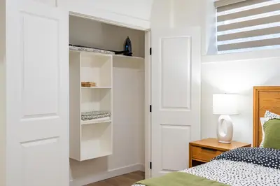 a bedroom with white closet doors and a bed at Free Parking - Beautyrest Beds - Heated Bath Floor in Calgary