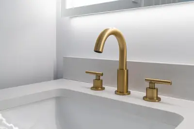 a kitchen sink with gold faucets on it at The Pines on 15th Ave - Hot Tub, BBQ in Invermere