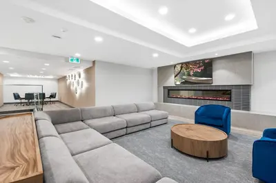 a living room with a couch and a table and chairs at AQUA Corner Unit w Balcony and Amazing View #614 in Kelowna