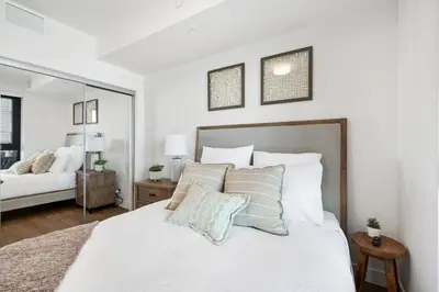 a bedroom with a large white bed with pillows at AQUA Corner Unit w Balcony and Amazing View #614 in Kelowna