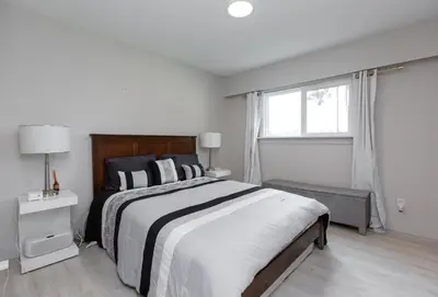 a white bedroom with a large bed and a window at Modern 5BR Luxury Getaway in Cobble Hill