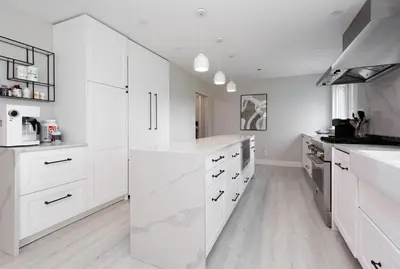 a white kitchen with white counters and white cabinets at Modern 5BR Luxury Getaway in Cobble Hill