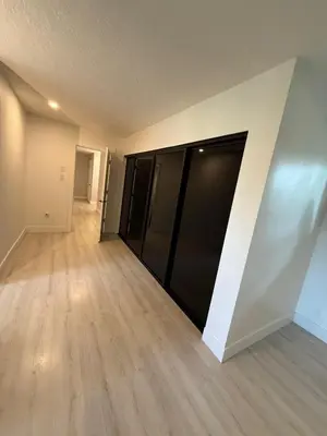 an empty room with black doors and wood floors at Modern 5BR Luxury Getaway in Cobble Hill