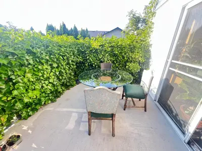 a table and chairs on a patio with a hedge at Cozy Nook in Fraser Valley Getaway with Breakfast in Abbotsford