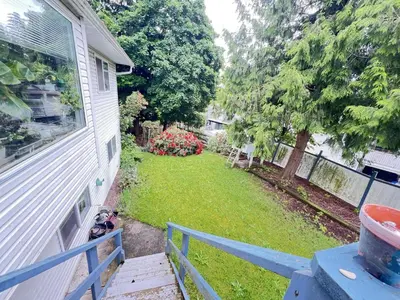 a yard with a fence and a house at Cozy Nook in Fraser Valley Getaway with Breakfast in Abbotsford