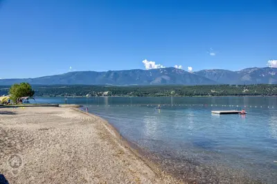 a body of water with mountains in the background at Akiskinook Resort by StayIn in Windermere