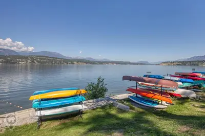 a group of boats parked on the shore of a lake at Akiskinook Resort by StayIn in Windermere