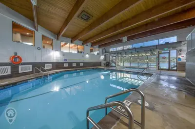 a large indoor swimming pool in a building at Akiskinook Resort by StayIn in Windermere