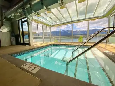 a large swimming pool with a large window at Akiskinook Resort by StayIn in Windermere
