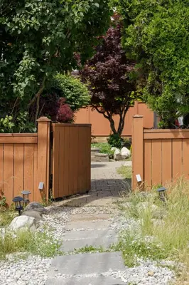 a wooden fence with a gate and a walkway at Cozy 1BR BSMT Escape Large Free Parking in Coquitlam
