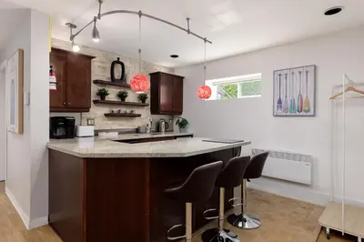 a kitchen with a counter and stools in it at Cozy 1BR BSMT Escape Large Free Parking in Coquitlam