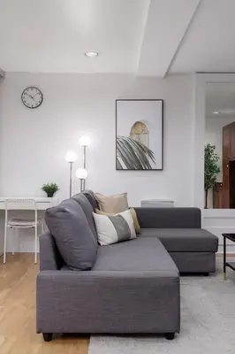 a living room with a gray couch and a table at Cozy 1BR BSMT Escape Large Free Parking in Coquitlam