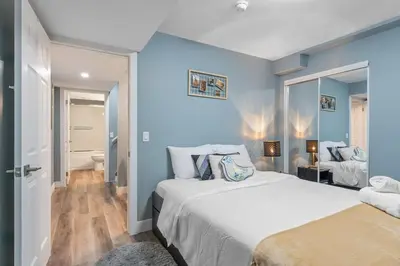 a bedroom with two beds and a blue wall at Private Family Entertainer's Suite in Calgary