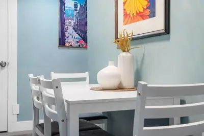 a white table with chairs and a vase on it at Private Family Entertainer's Suite in Calgary