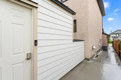 a white garage door next to a building at Private Family Entertainer's Suite in Calgary